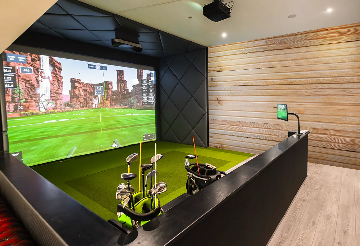 Indoor golf simulator in a timber cabin with golf clubs and wood panel walls