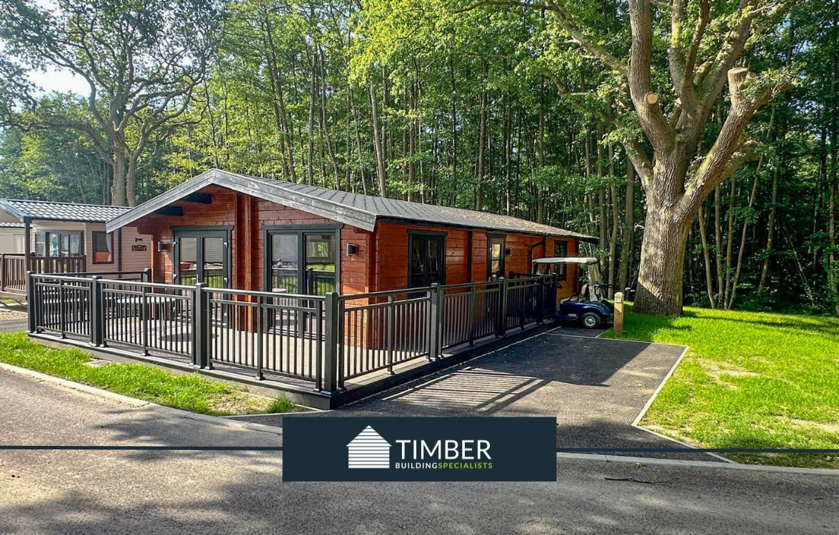 Modern timber log cabin lodge with large deck in forest setting, durable wooden construction