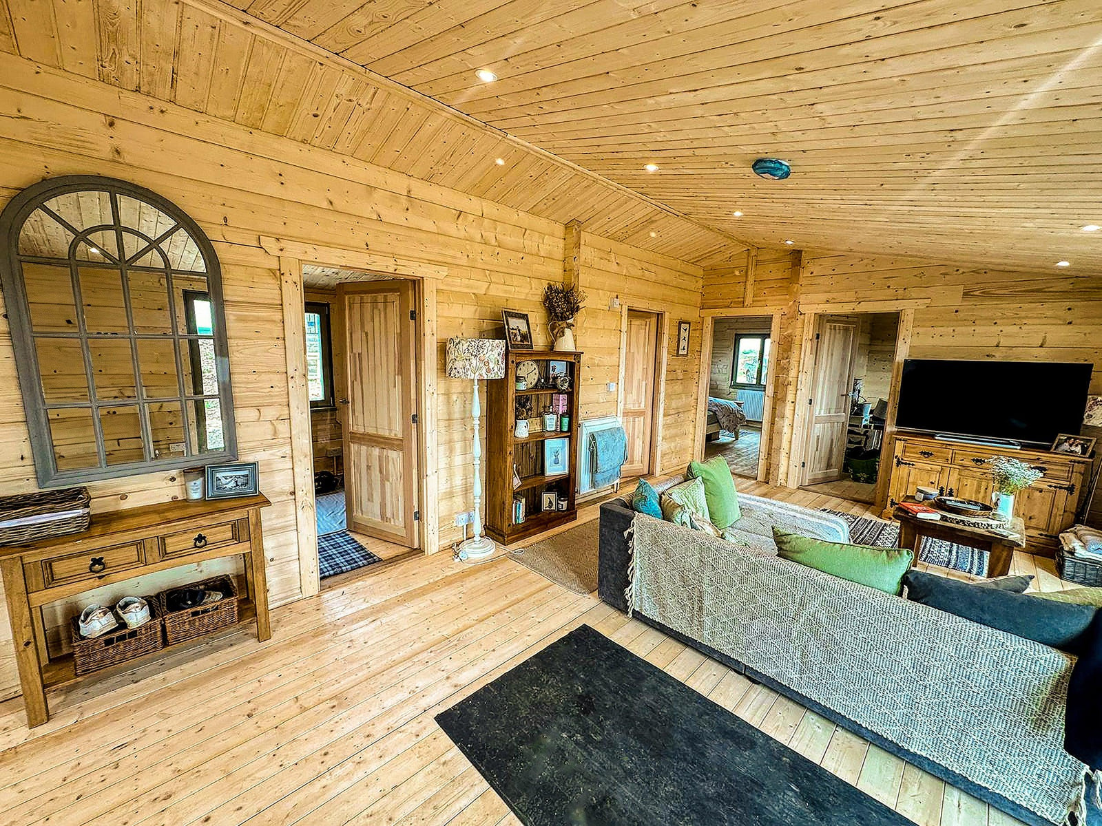 Spacious log cabin interior with wooden walls, open living area, and modern furnishings