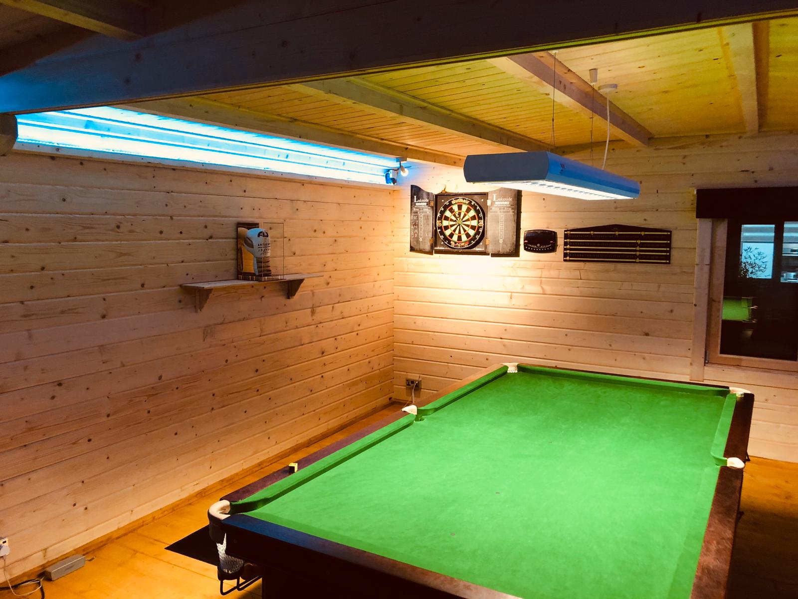 Timber games room with snooker table and dartboard under wooden ceiling
