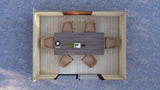Top-down view of a dining area with a table and chairs on a textured blue floor. Low threshold and tongue and groove timber floor inside Dean modern log cabin with sliding doors