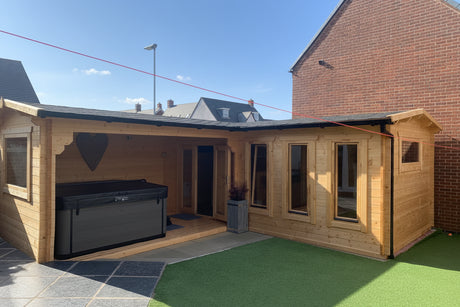 l-shaped log cabin in a garden, with a hot tub and bar in the timber building