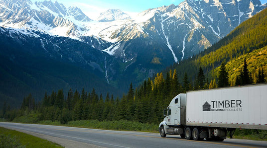 timber building specialists truck delivering in the mountains